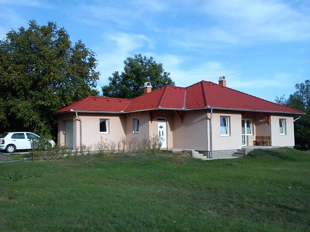 TordasBokros Vendégház的草场上一座红色屋顶的房子