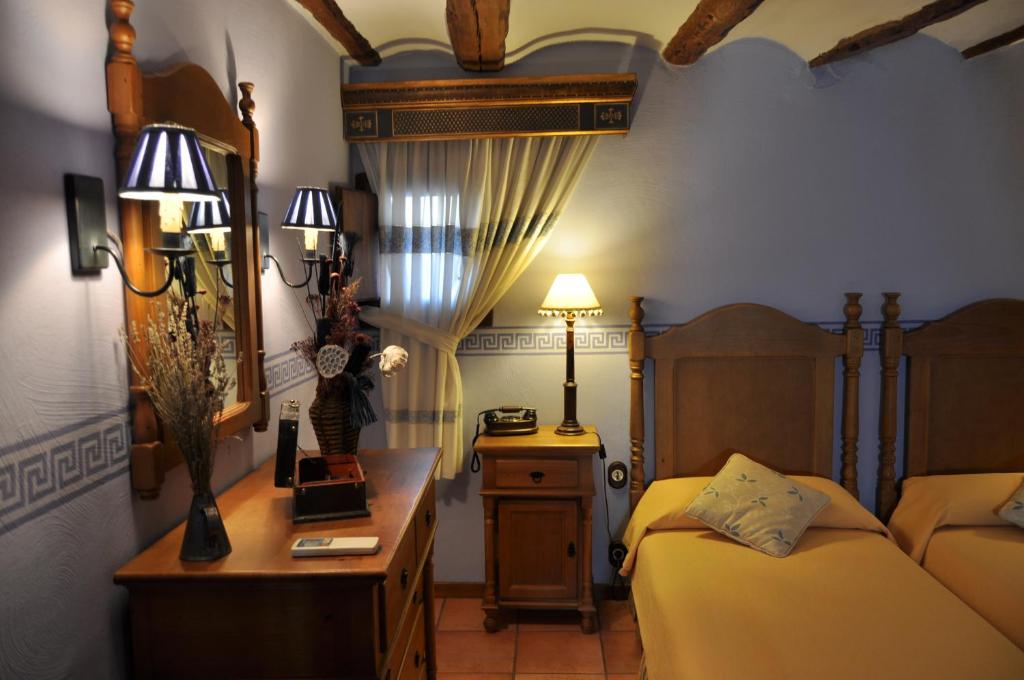 阿尔巴拉辛卡萨德尔阿布罗酒店的一间卧室配有两张床、一张桌子和一面镜子