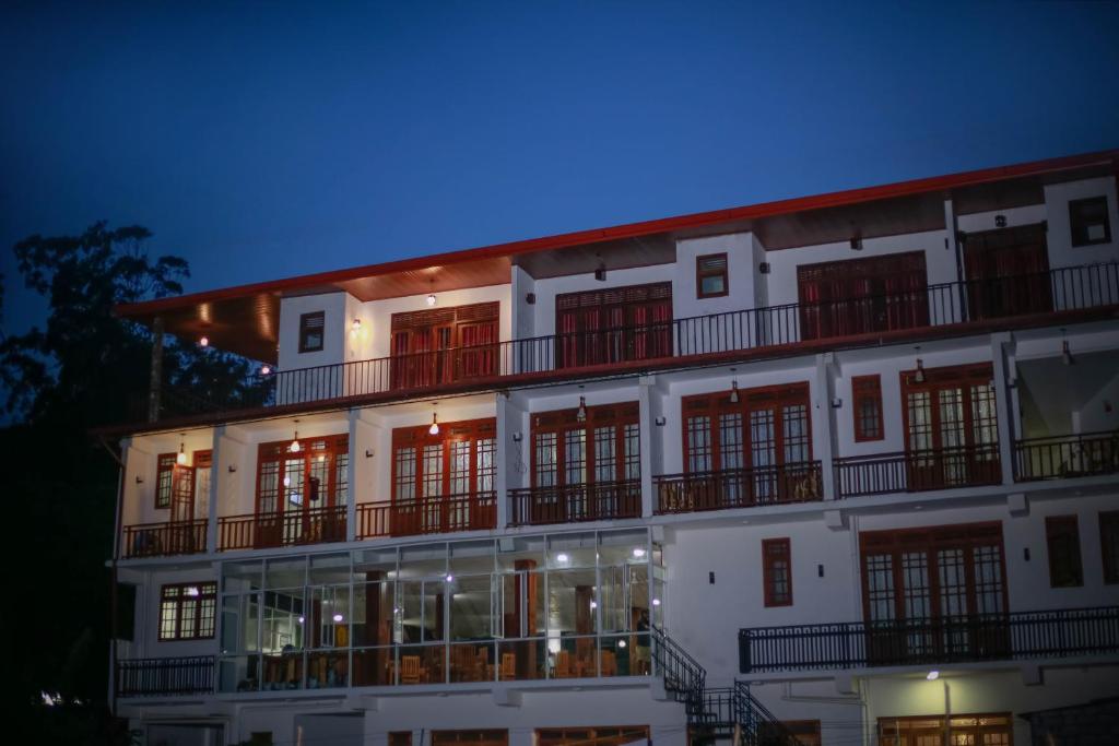 埃拉埃拉格兰德城市酒店的一座白色的大建筑,晚上有红色的窗户