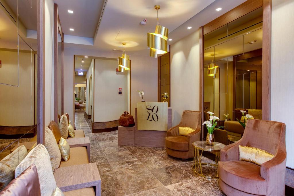佛罗伦萨索罗体验酒店的大楼内一个带沙发和椅子的大堂