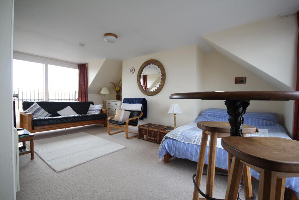 锡豪西斯Sunnieside Cottage的一间卧室设有一张床和一间客厅。