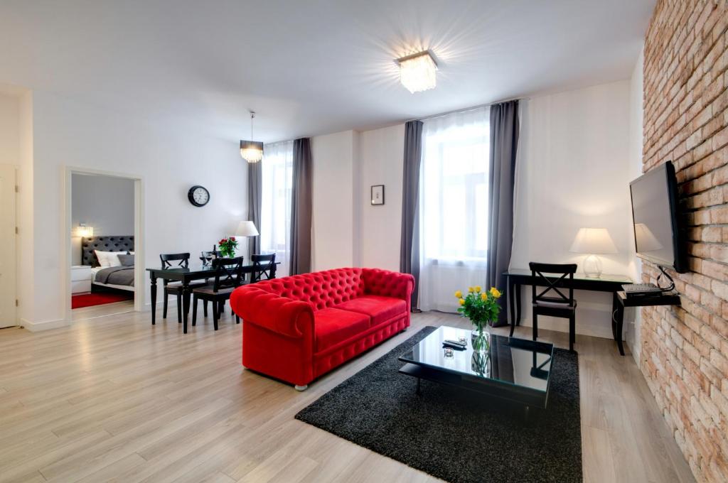 克拉科夫扎克瓦15公寓式酒店的客厅配有红色的沙发和桌子