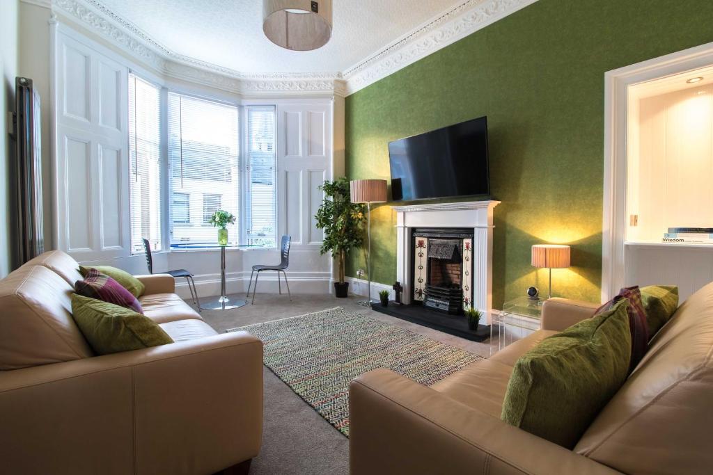 米尔盖West Highland Apartments Milngavie - The Nevis的带沙发和壁炉的客厅