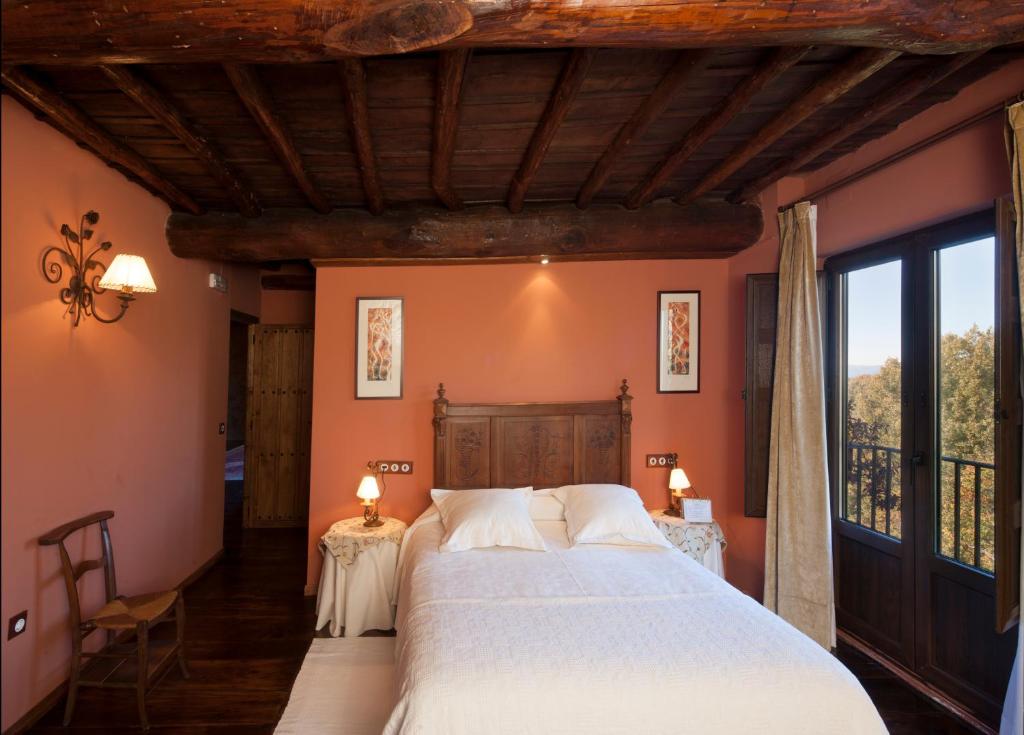 皮尔托贝加Posada Real Ruralmusical的一间卧室配有一张带橙色墙壁的大床