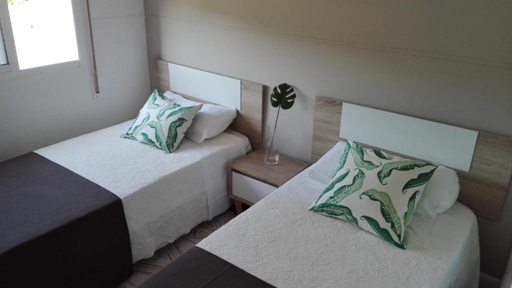 卡尔达斯·德·雷斯Marvera的小客房内的两张床,配有四柱床和四柱床