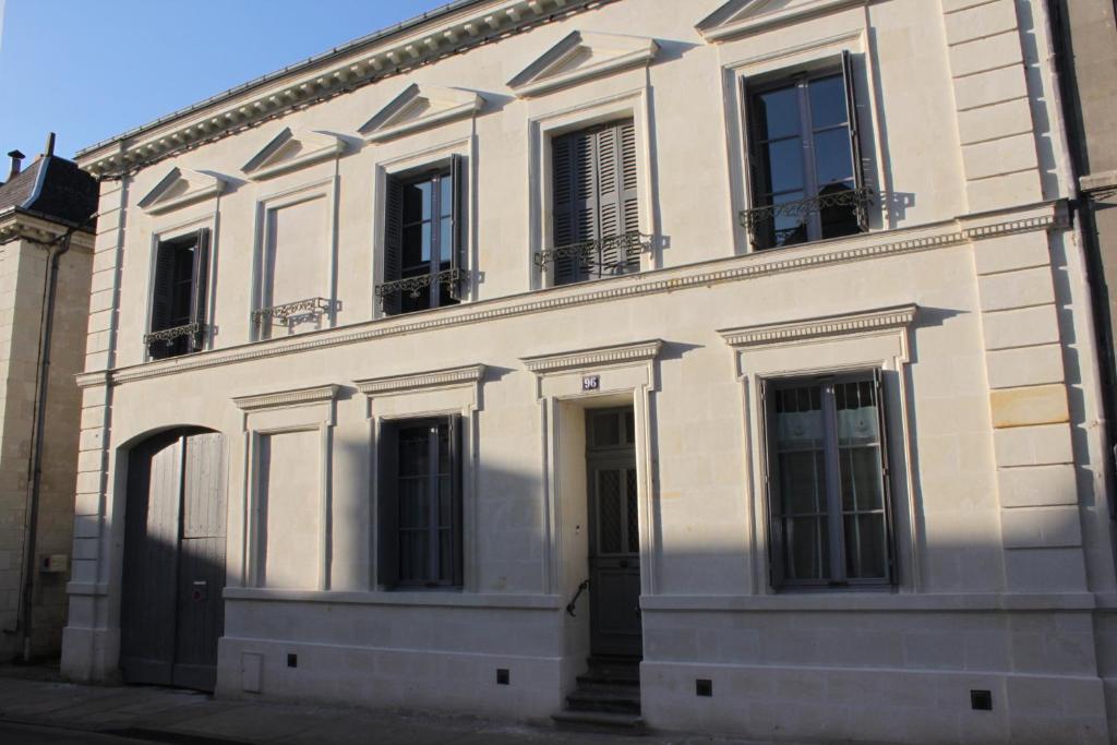 朗热La Vie Voyage的一座白色的大建筑,设有黑色的大门和窗户