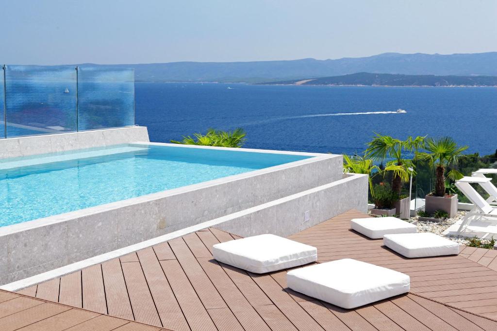 波尔Lifestyle Hotel Vitar - Adults Only的一个带2把躺椅的游泳池和海洋