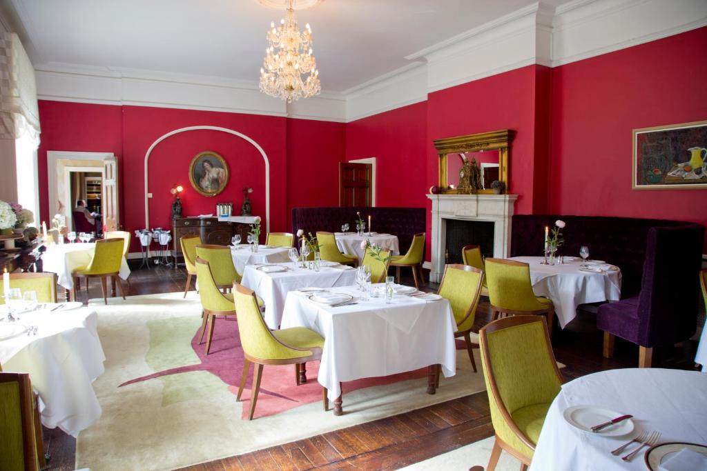 阿瑟斯敦邓布鲁蒂田园酒店的用餐室配有白色的桌子和黄色的椅子