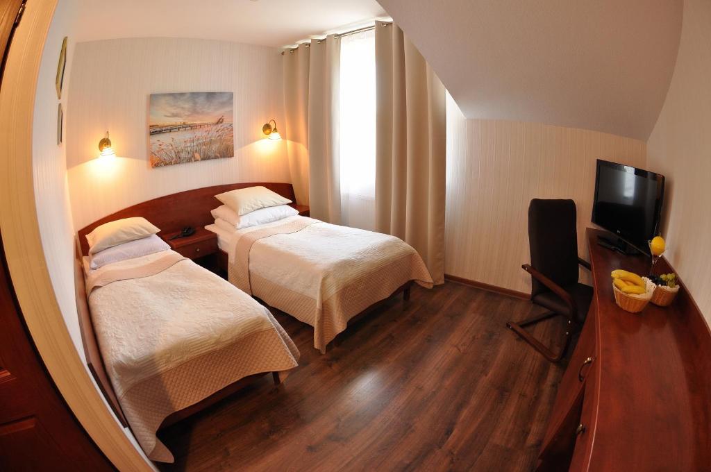 克拉科夫莱奥波利斯酒店的酒店客房,设有两张床和镜子