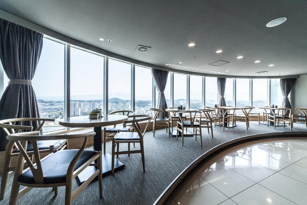 江陵市江陵旅游饭店的餐厅设有桌椅和大窗户。