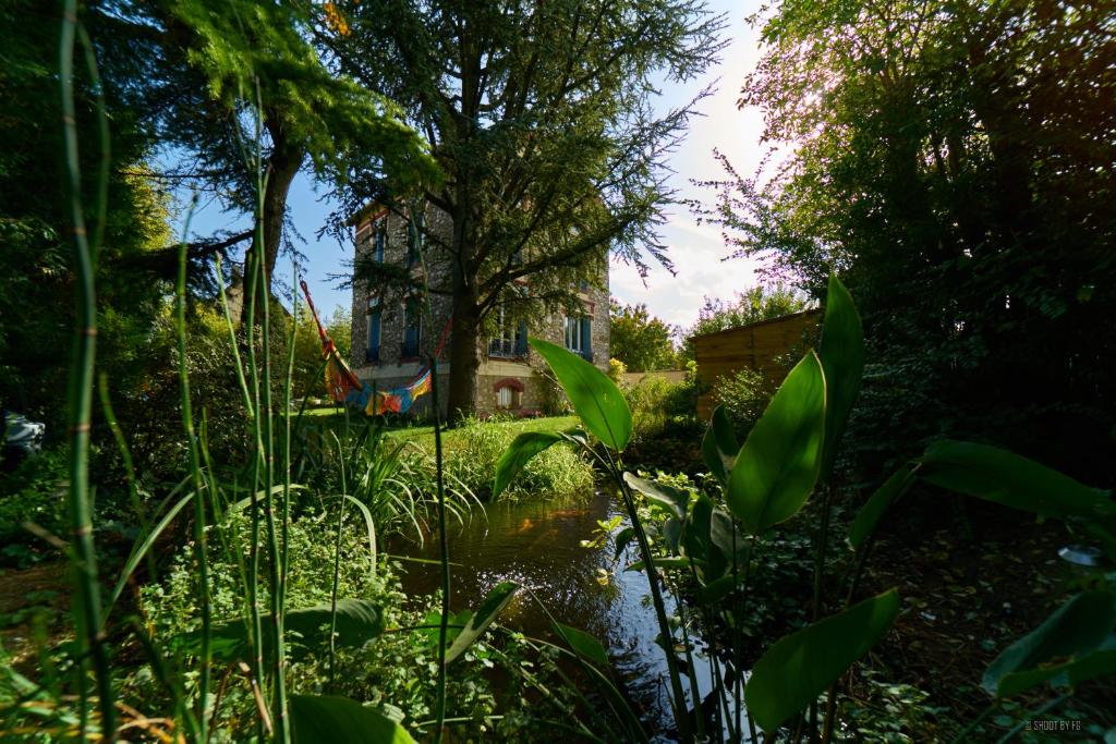 马恩河畔布里Gite bord de Marne Paris的房屋前带池塘的花园