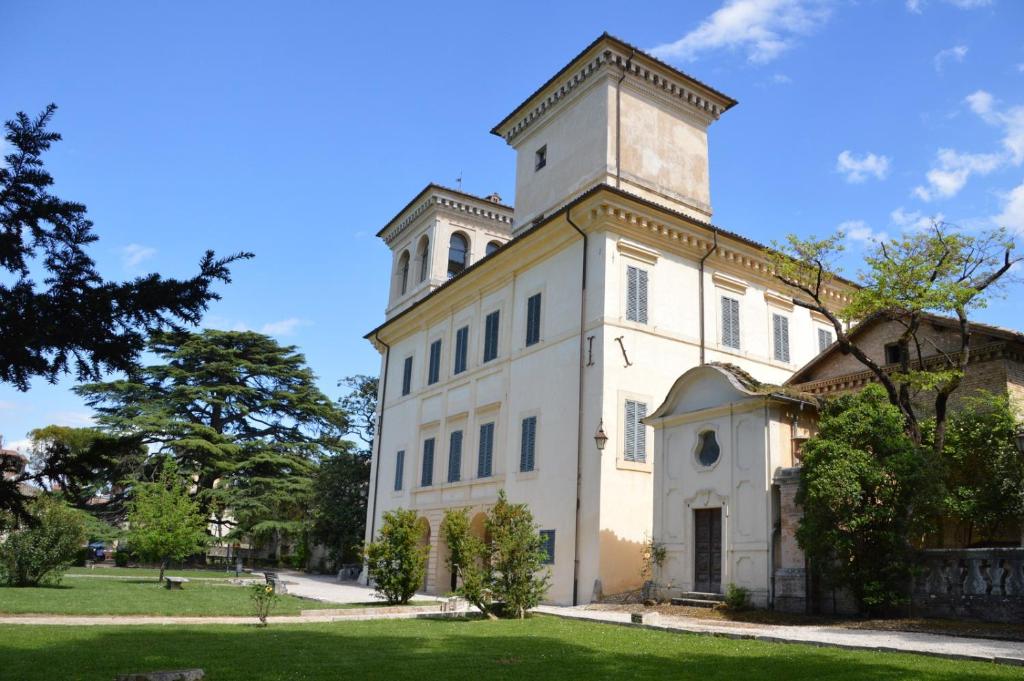 斯波莱托Ostello Villa Redenta的一座白色的大建筑,顶部有塔