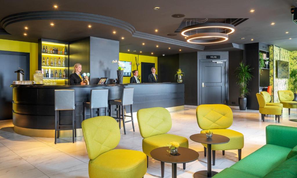 莫尔德索恩莫德峡谷酒店的餐厅内的酒吧,设有黄色和绿色的椅子