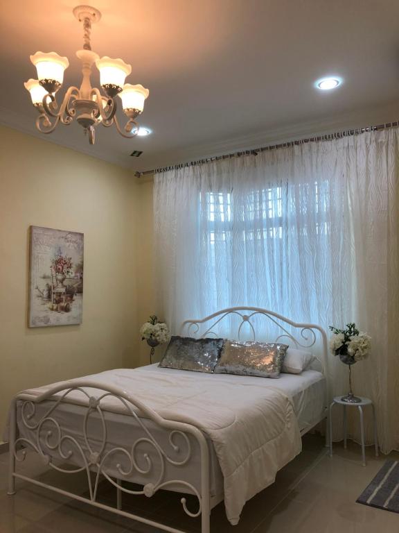 哥打巴鲁AAM Hotel的一间卧室配有一张带吊灯和窗户的床。