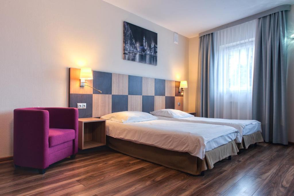 克拉科夫Hotel Major Budget的酒店客房,配有一张床和一张紫色椅子