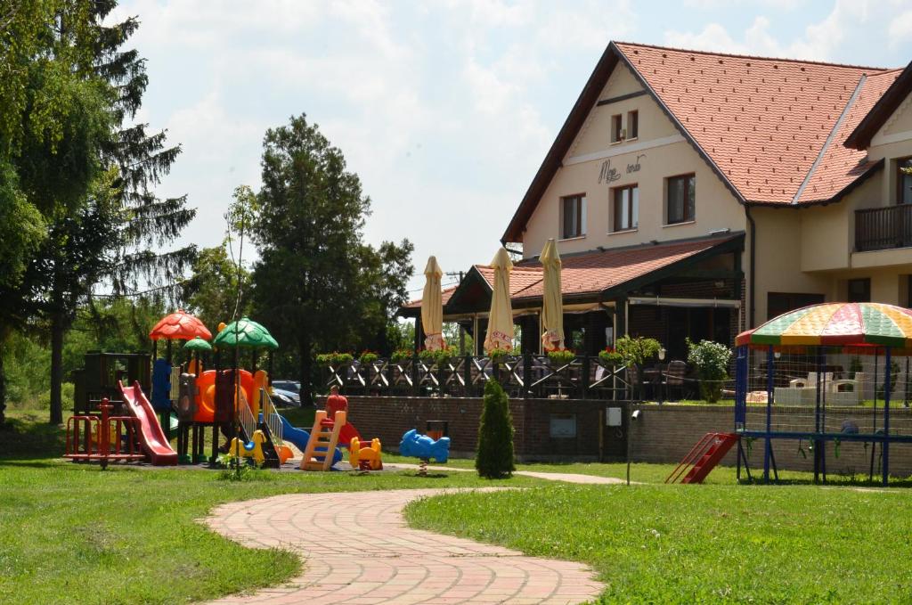 TemerinHotel Moja Čarda的公园设有带滑梯和遮阳伞的游乐场