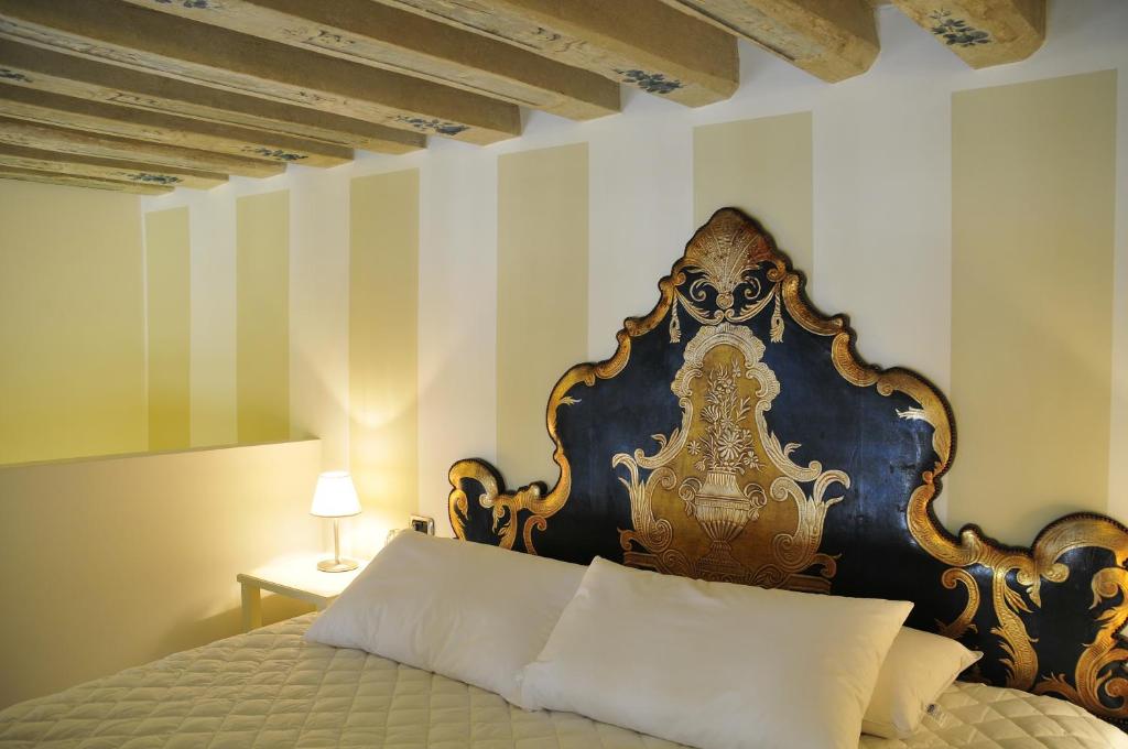 威尼斯卡玛莉酒店的一间卧室配有一张带蓝色和金色床头板的床