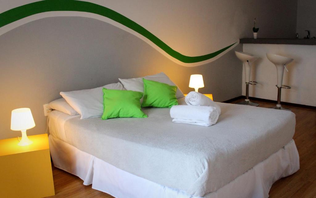 蒙得维的亚拉加托旅社蒙得维的亚旅馆的一间卧室配有带绿色和白色枕头的床