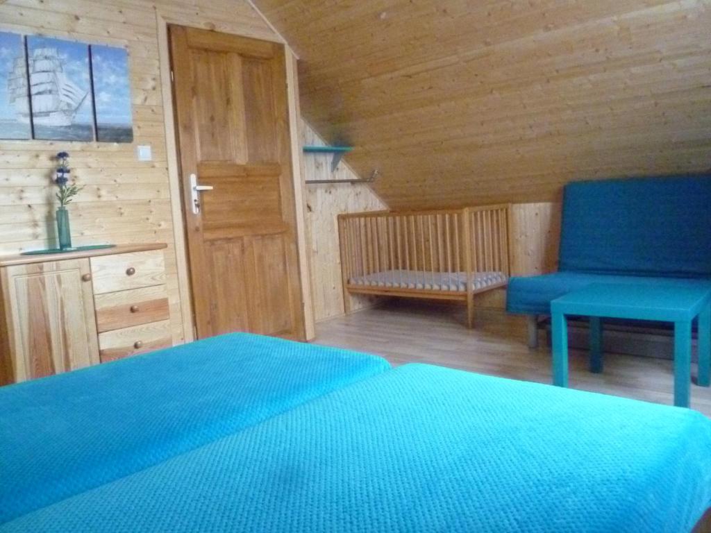 弗瓦迪斯瓦沃沃Tęczowe Domki的一间卧室配有蓝色的床和蓝色椅子