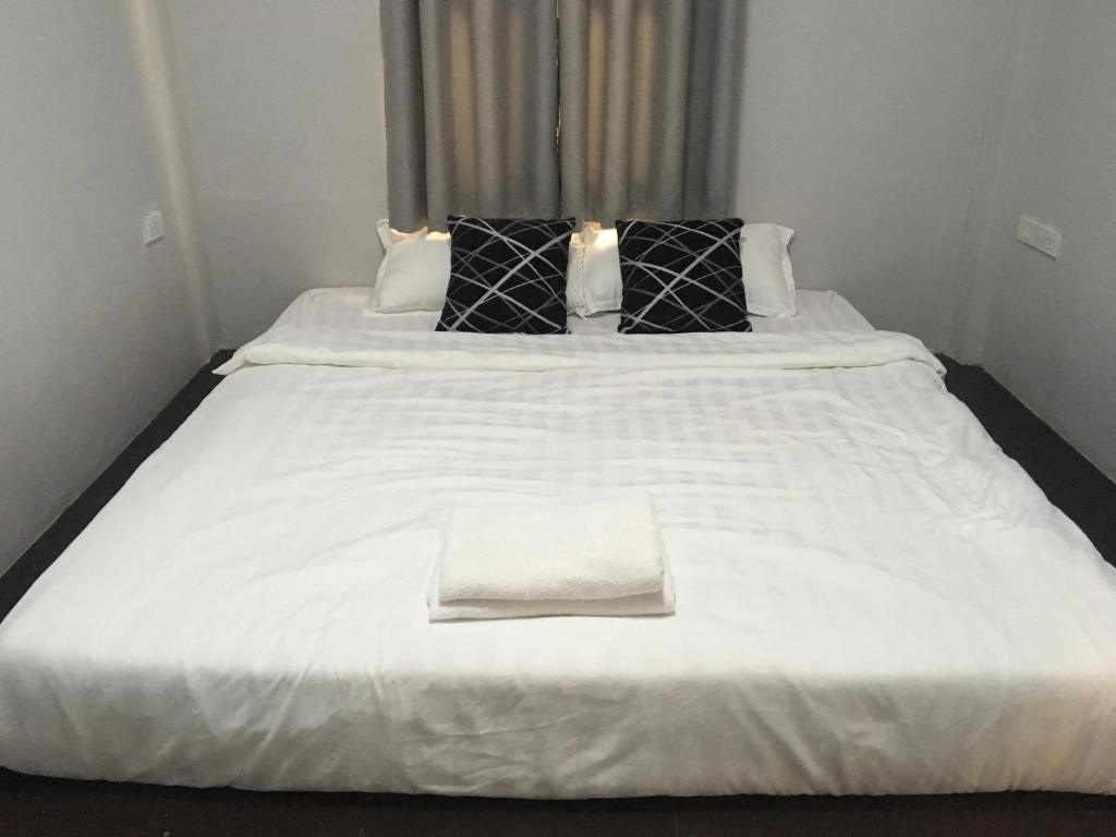 万象湄公河畔旅馆的一张白色的大床,上面有白色毛巾