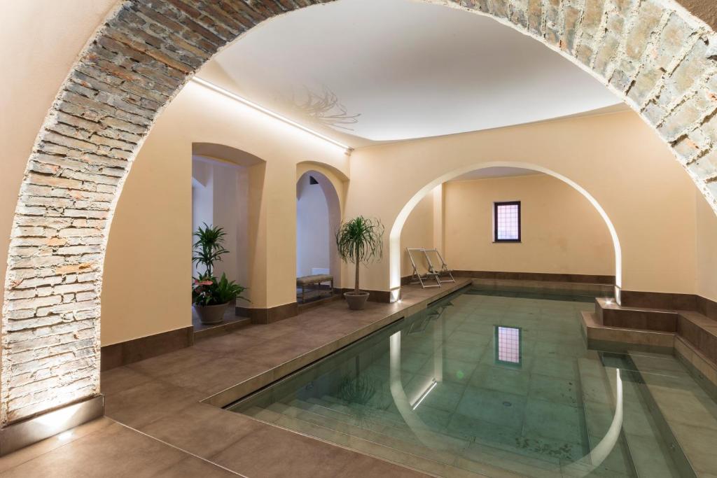 利沃诺Agave in Città的一座带砖墙和拱门的室内游泳池