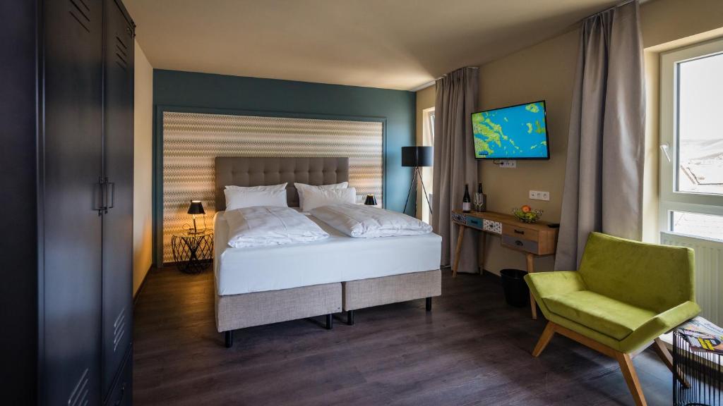 特拉本特拉巴赫Hotel Goldene Traube - by Neugart的一间卧室配有一张床、一把椅子和电视
