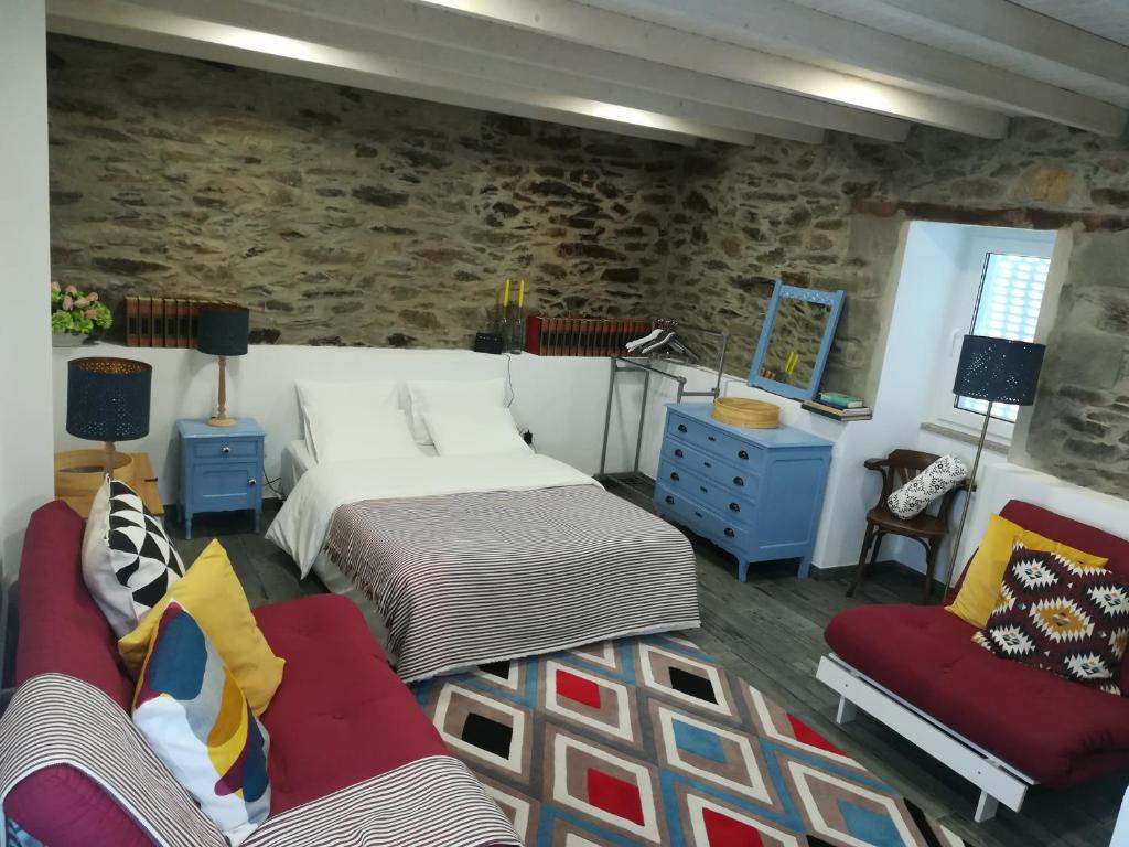 维拉·雷阿尔A Tasca的一间卧室设有两张床和石墙