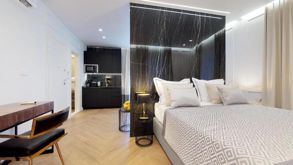 斯普利特Illyria Luxury Studio Apartments的一间卧室配有一张大床、一张桌子和一张书桌