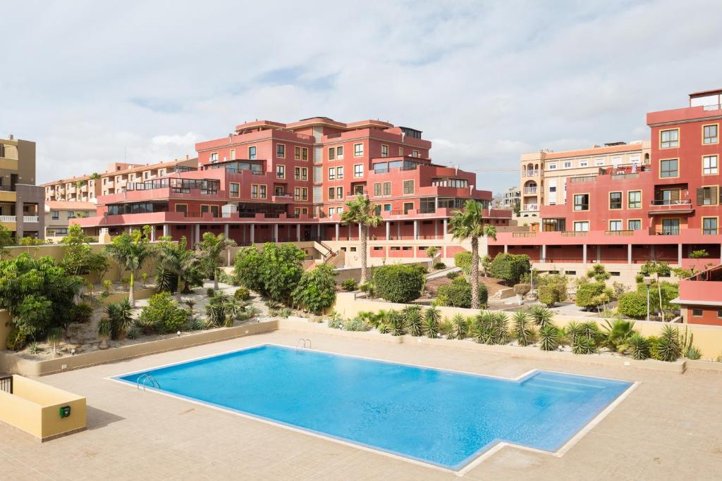厄尔梅达诺110 MEDANO Relax Holiday Home的一座公寓大楼的图片,设有一个游泳池