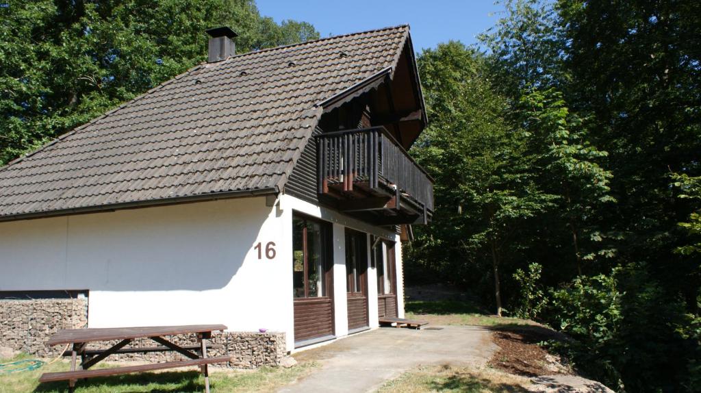 弗兰克瑙Waldeck的一座白色的小建筑,设有阳台和长凳