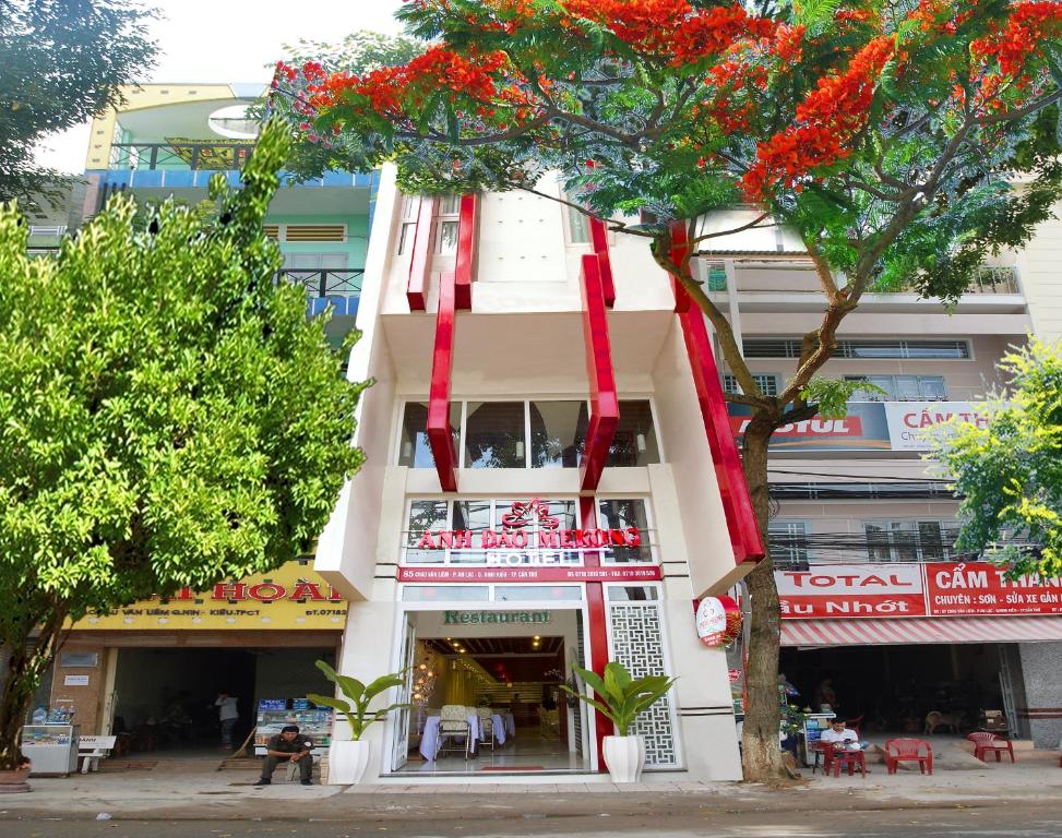 芹苴湄公河樱桃酒店的一座白色的建筑,上面挂着红色的 ⁇ 带