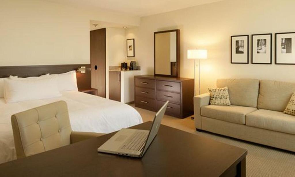 圣乔治斯勒乔治村酒店的酒店客房配有一张床铺和一张书桌上的笔记本电脑