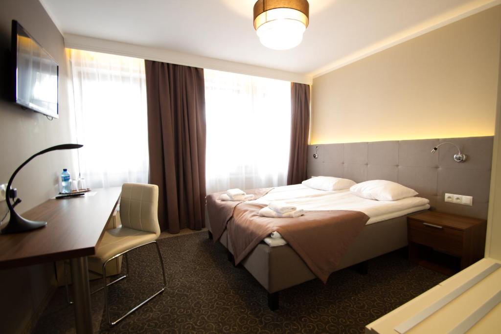 卡尔帕奇Hotel Kolorowa的配有一张床和一张书桌的酒店客房