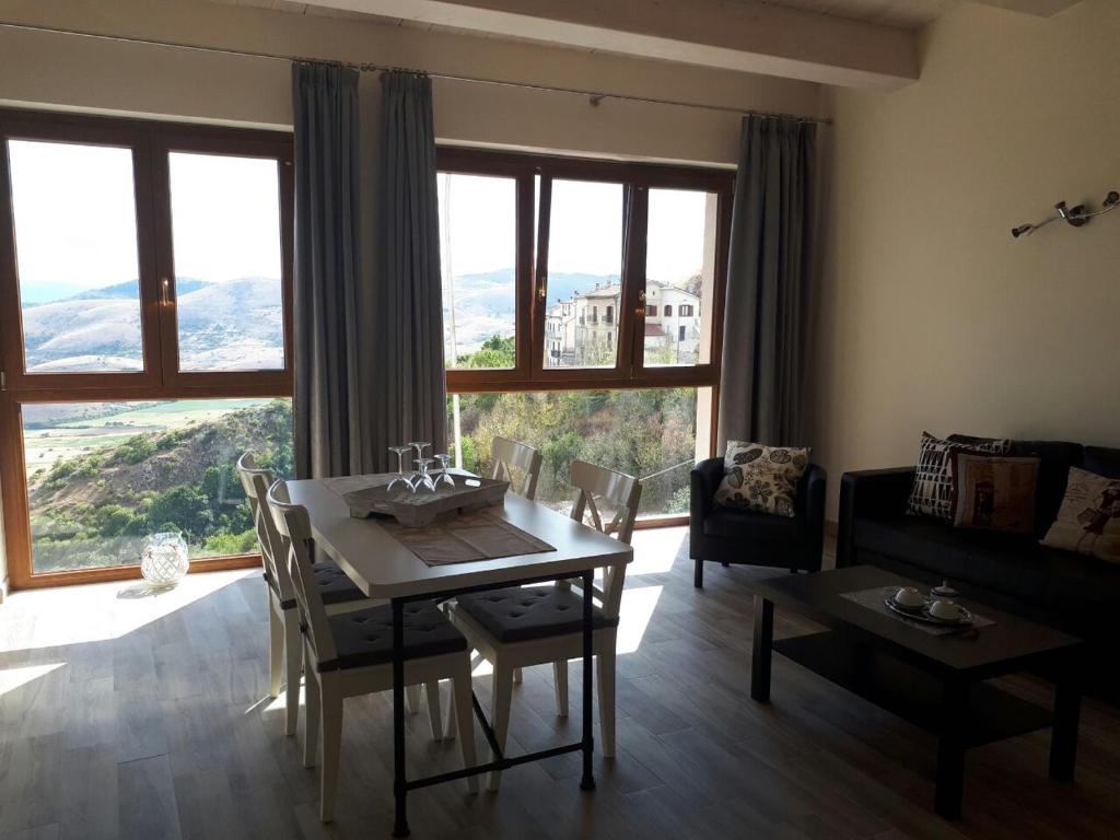 蒙特堡Appartamenti Raggio di Sole的客厅配有桌椅和大窗户