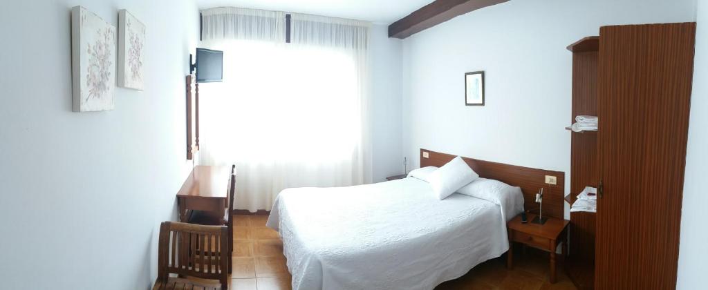 VimianzoPensión Vázquez的卧室配有白色的床和窗户。