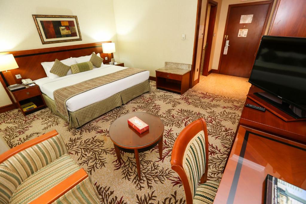 迪拜皇家苎麻酒店的酒店客房,配有床和电视