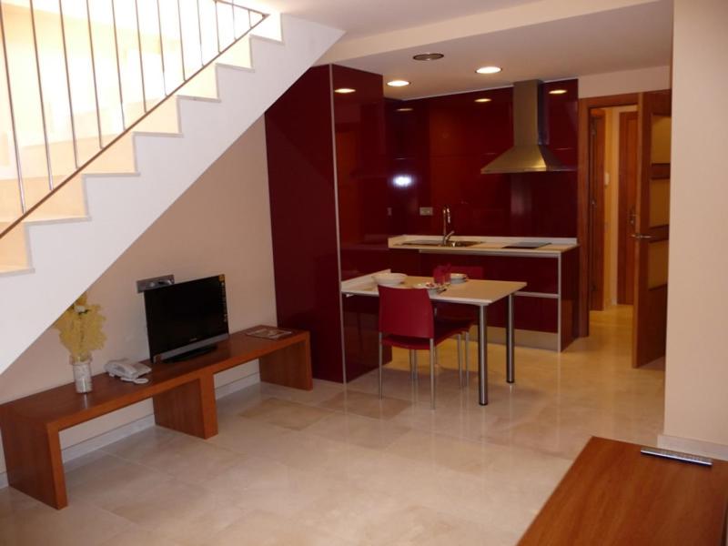 Corró de Vall维尔提酒店的客厅设有厨房、餐桌和楼梯。
