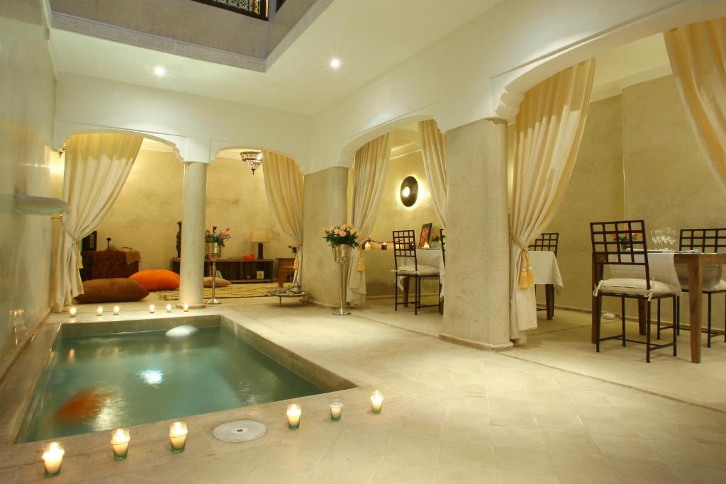 马拉喀什Riad CHERRATA的大型浴室设有蜡烛浴缸