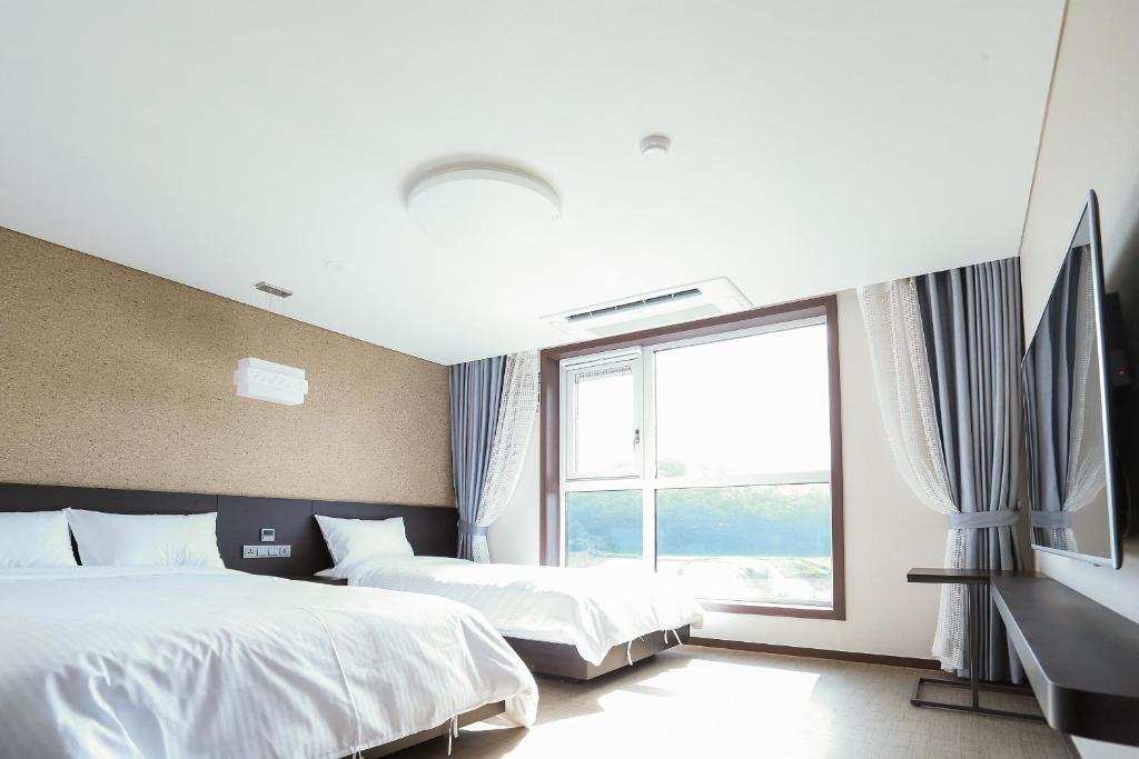西归浦市济州宋山酒店的酒店客房设有两张床和窗户。