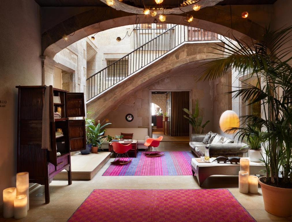 巴塞罗那Hotel Neri – Relais & Chateaux的一个带楼梯和沙发的大客厅