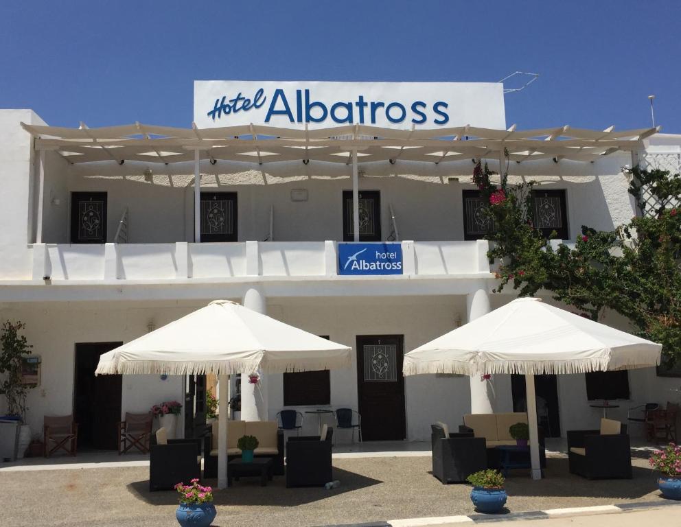 利瓦迪奥Hotel Albatross的建筑物前的两把白色遮阳伞