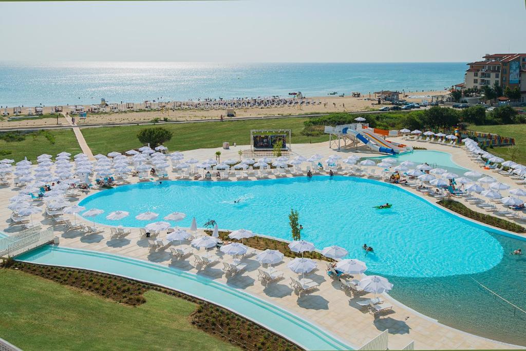奥布佐尔Sunrise Blue Magic Resort - All Inclusive的享有带遮阳伞和海滩的游泳池的顶部景致