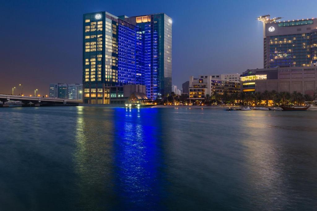 阿布扎比Beach Rotana Residences的一座有高楼和夜河的城市