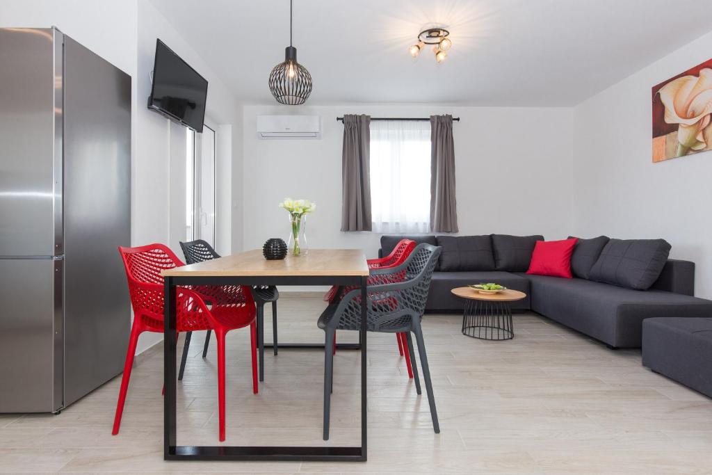 普纳特Apartments Kiara的客厅配有桌子和红色椅子