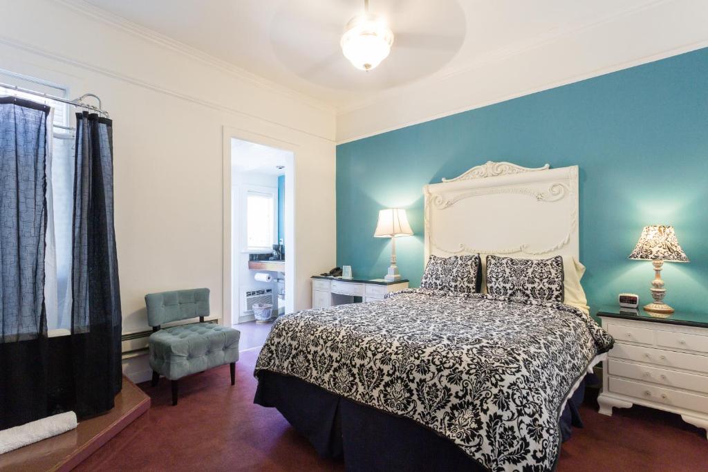 圣拉斐尔Panama Hotel and Suites的一间卧室设有一张床和蓝色的墙壁
