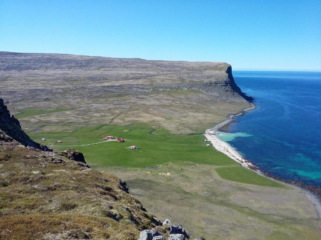 Hnjótur翰努维克度假屋的享有毗邻大海的高尔夫球场的空中景致