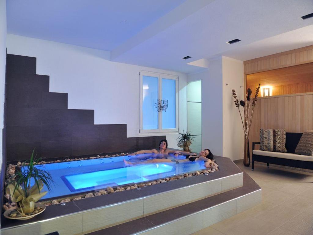 科姆梅扎杜拉比奥班尼酒店的两人坐在客厅的游泳池里
