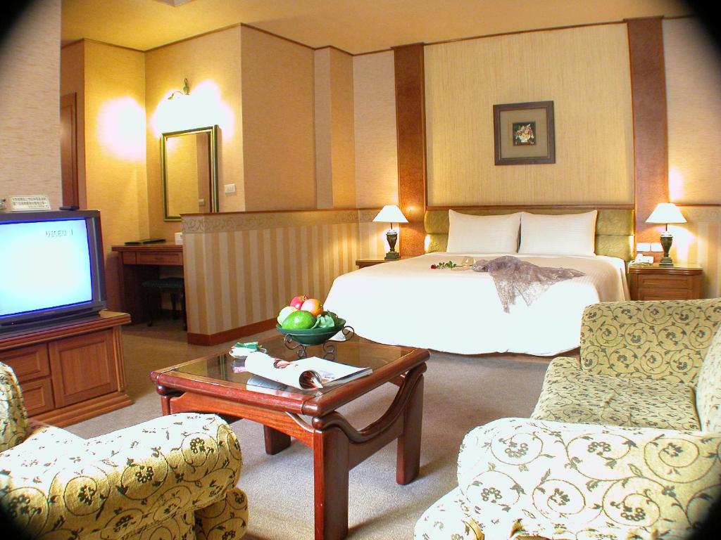 嘉义市柏克山庄汽车旅馆的酒店客房,配有床和电视