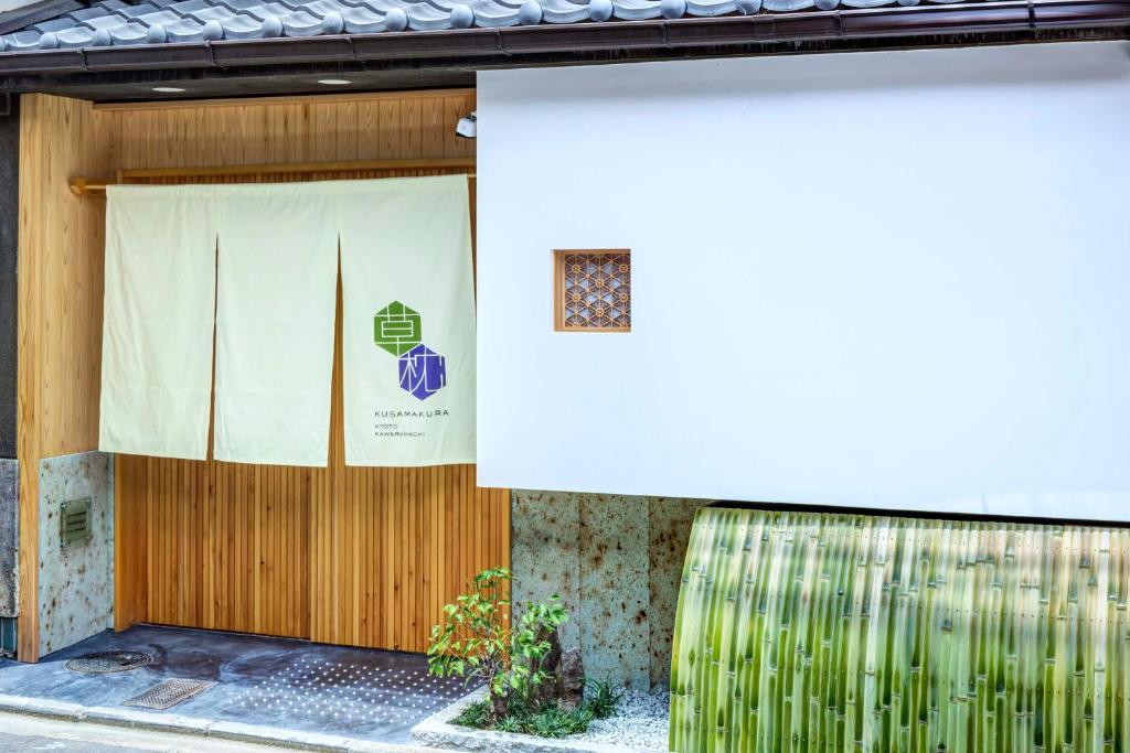 京都Kusamakura Kyoto Kawaramachi的建筑物前门,带窗帘