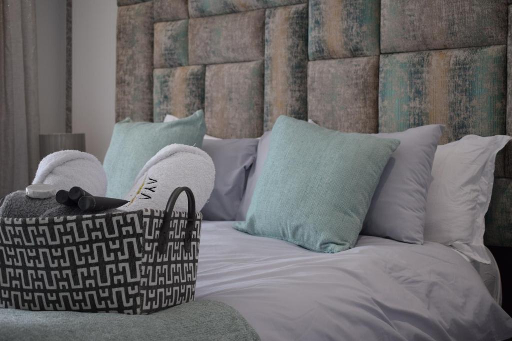 德班Aya Luxury Apartment 84的一间卧室配有一张带大床头板和枕头的床